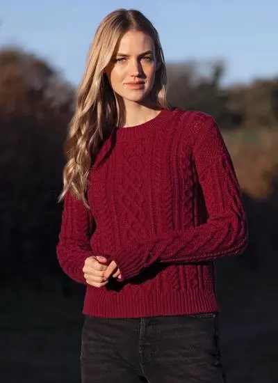 blonde woman wearing bright berry red sweater with aran stitch overall design