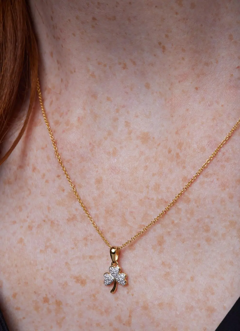 Décolletage shot of red haired woman wearing 14Ct Gold Vermeil Shamrock Pendant with Cubic Zirconia