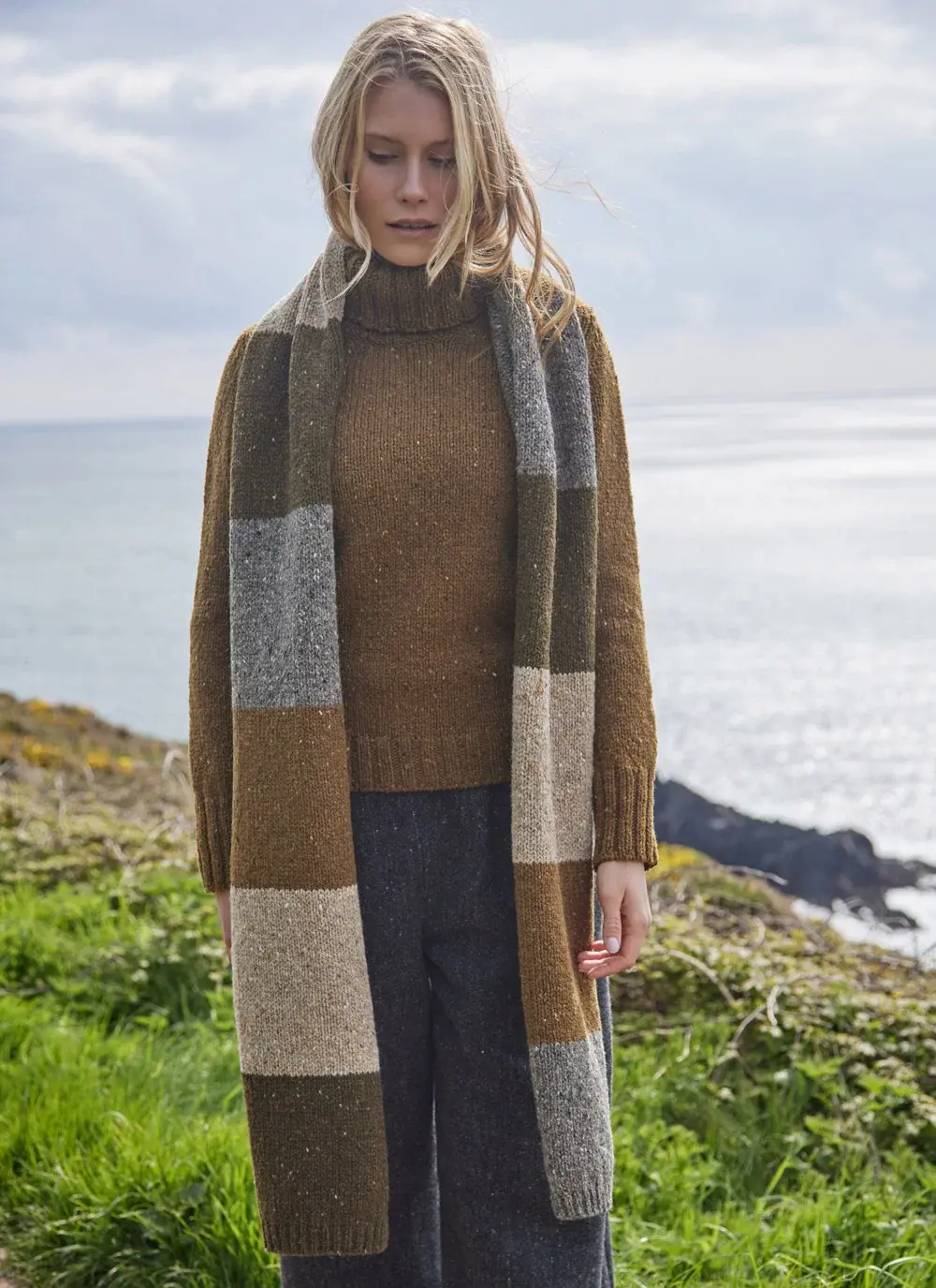 Woman wearing woolen brown toned scarf with sea in background