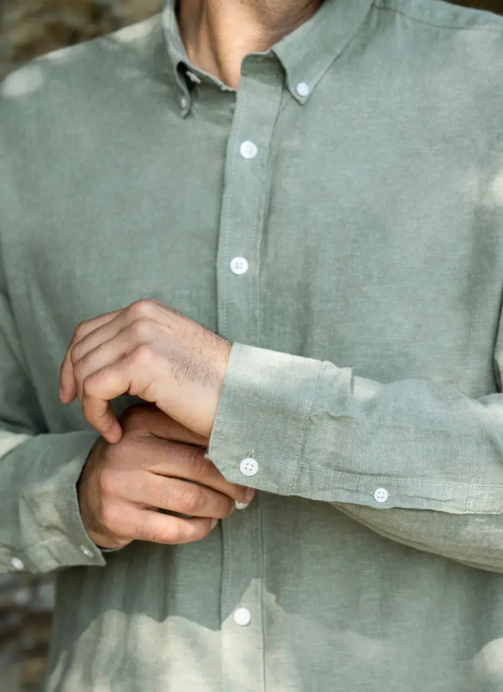 Detail of shirt cuff and sleeve – white buttons on the Finn Cotton Linen Shirt in Green with precise stitching and finish.