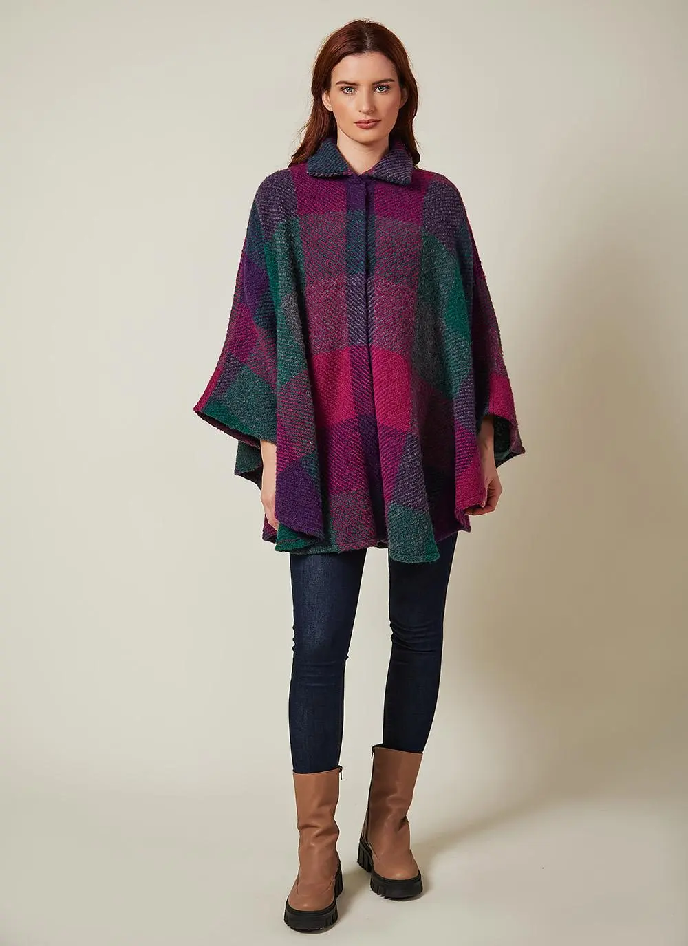 Full length studio shot of auburn haired woman wearing wool purple toned cape.