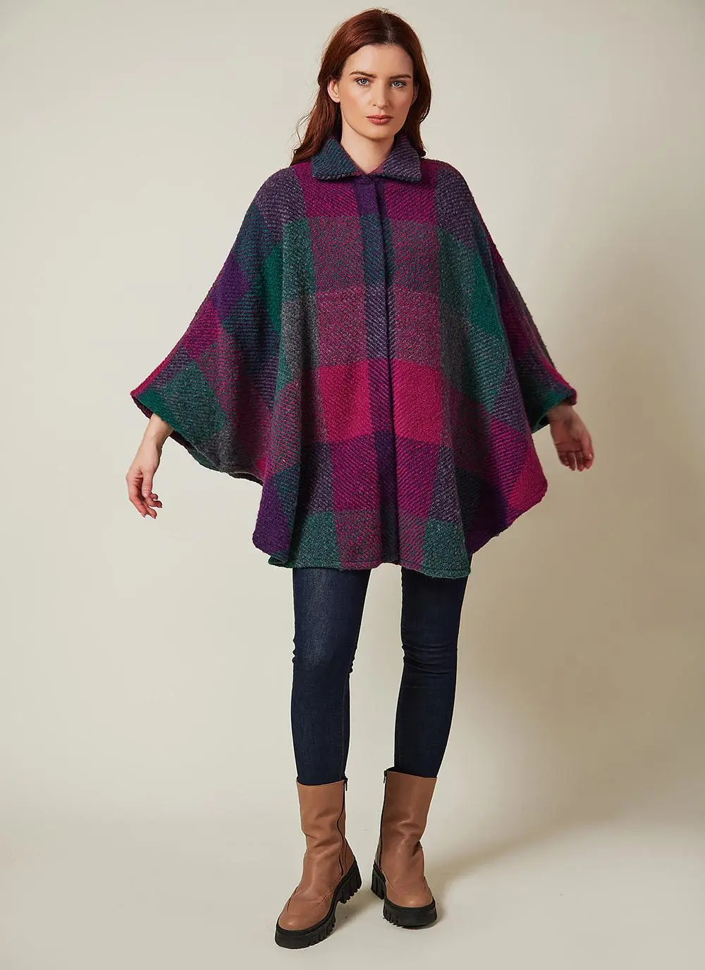 Studio shot of auburn haired woman wearing wool purple toned cape.