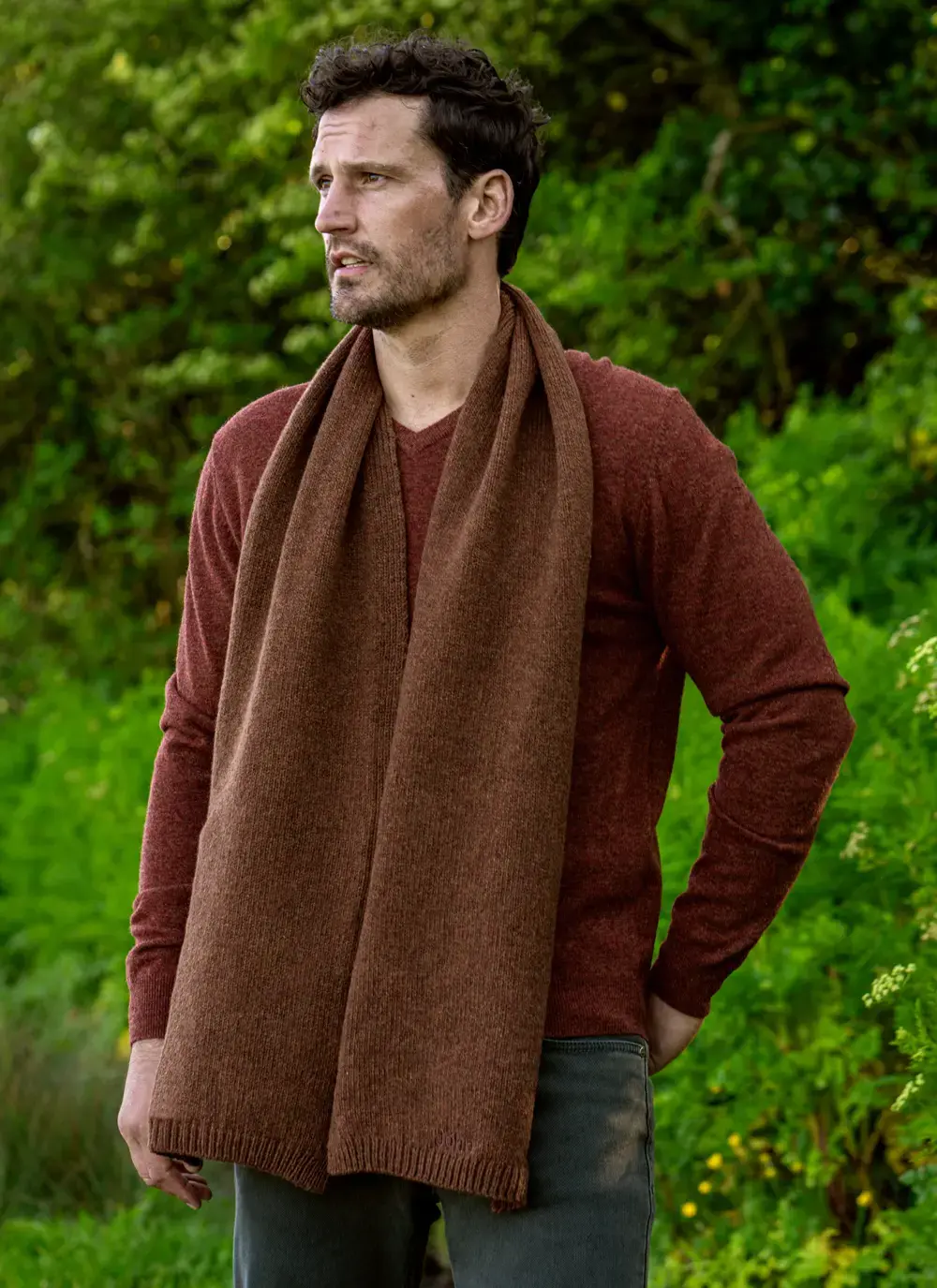 Personalized wool cashmere scarf in chestnut brown, made in Ireland, worn with rust sweater in forest backdrop