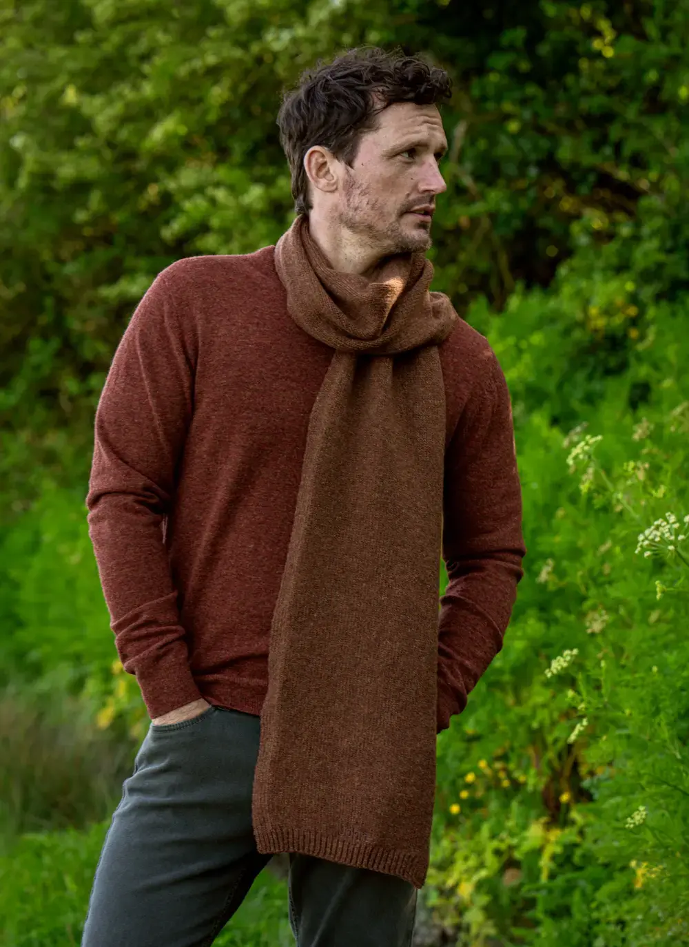 Personalized wool cashmere scarf in chestnut brown, made in Ireland, worn with rust sweater in forest backdrop