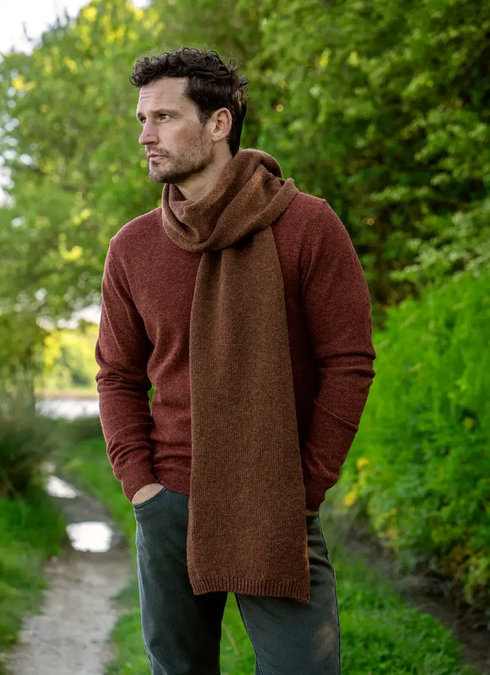 Personalized wool cashmere scarf in chestnut brown, made in Ireland, worn with rust sweater in forest backdrop