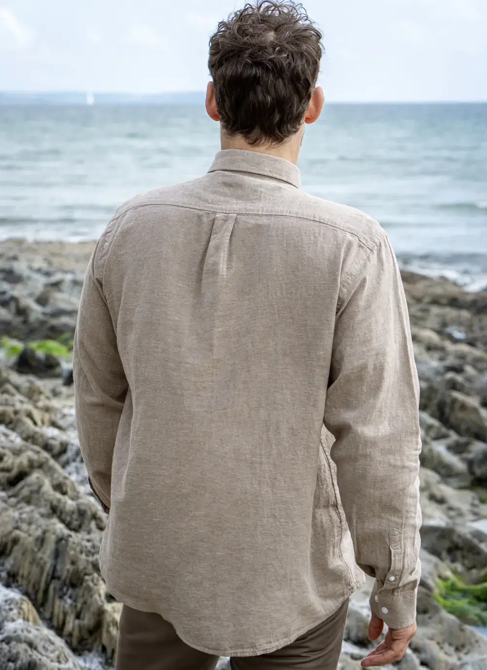 Back view of Finn cotton linen shirt worn by man, ocean horizon in background