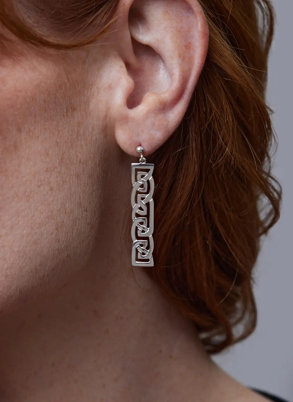 Close up of red haired model wearing Sterling Silver Contemporary Celtic Drop Earrings