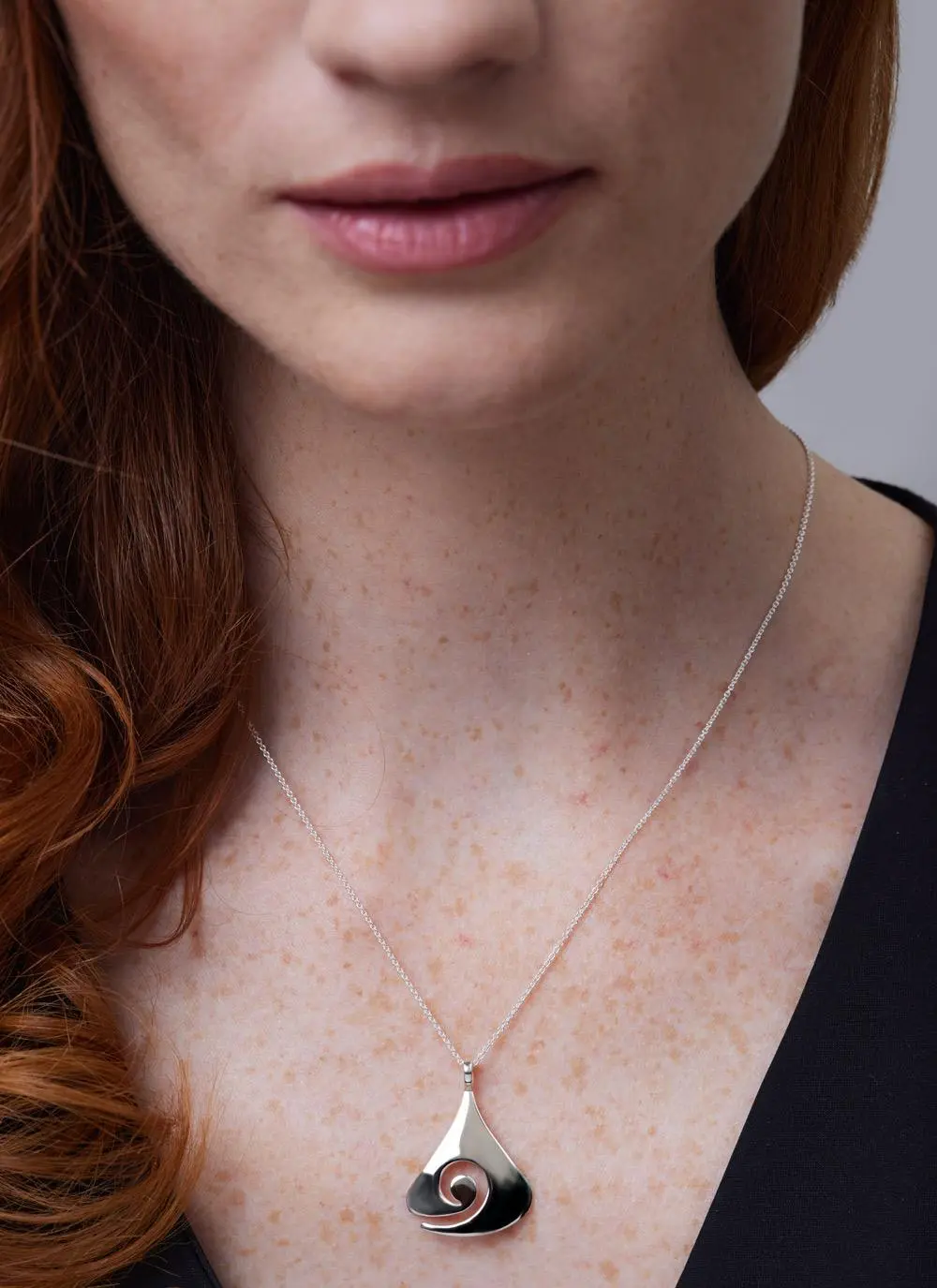 Close up of red haired model wearing Sterling Silver Contemporary Celtic Swirl Pendant