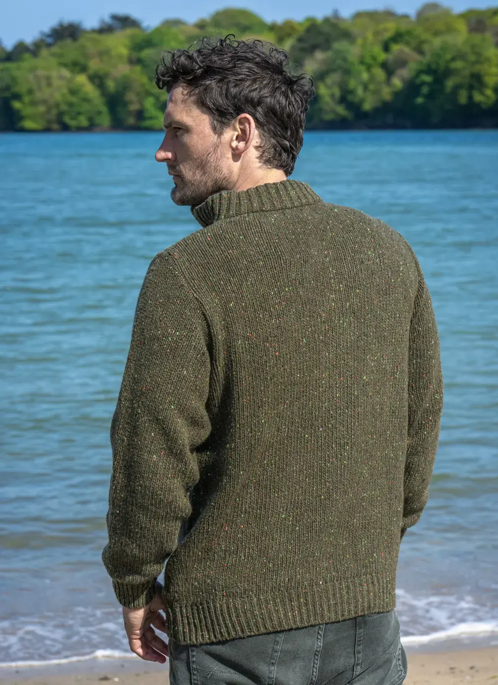 Back view of Glenstone 1/2 Zip Sweater showing speckled wool texture and ribbed hem, styled in a coastal outdoor setting.