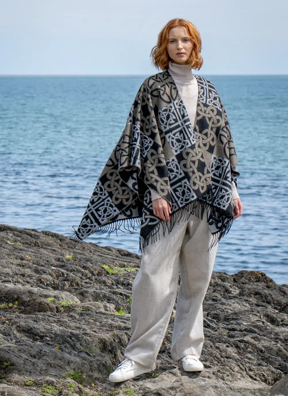 Red head model standing in front of water in black celtic knot shawl
