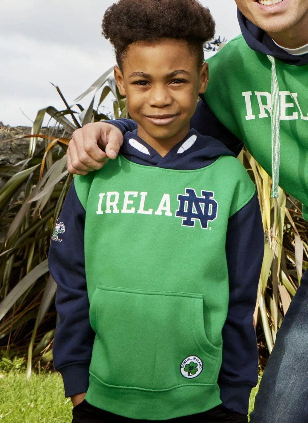 Kids hoodie with green torso, navy sleeves and hood, Ireland printed in the middle with fighting Irish logo