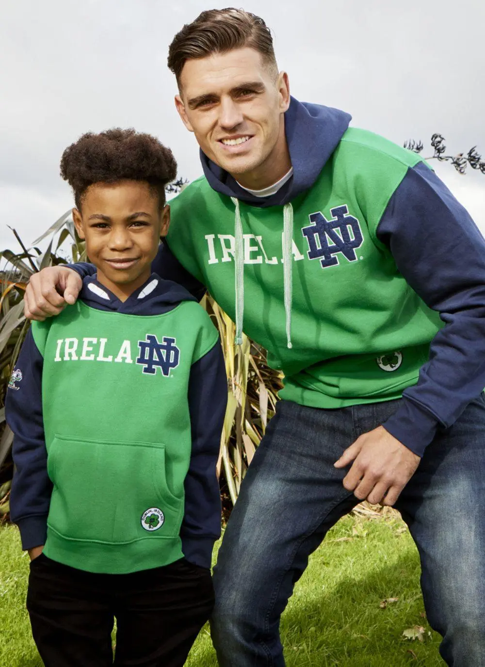 Kids hoodie with green torso, navy sleeves and hood, Ireland printed in the middle with fighting Irish logo