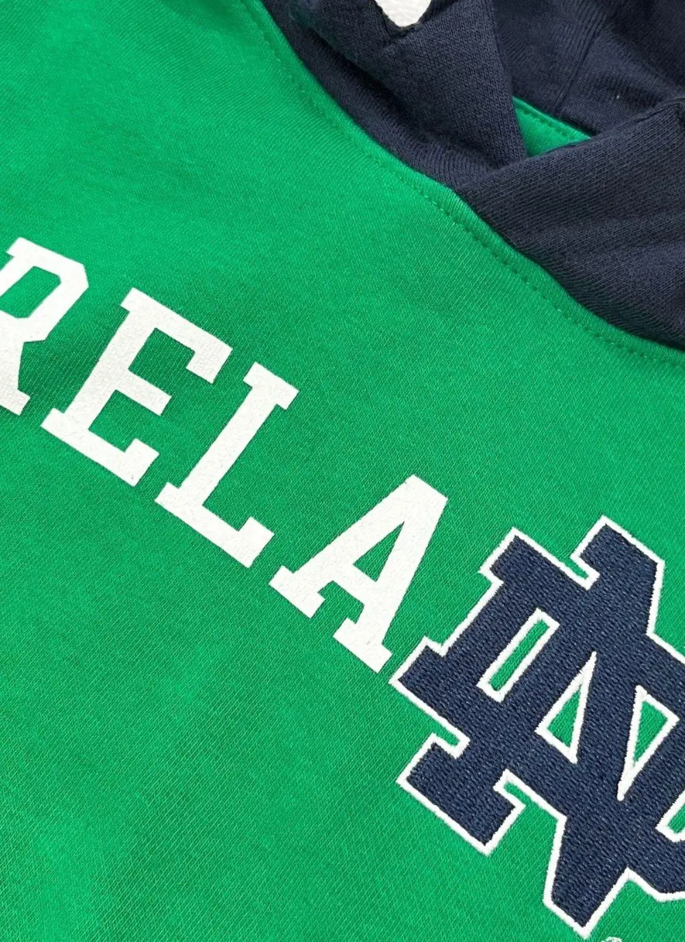 Kids hoodie with green torso, navy sleeves and hood, Ireland printed in the middle with fighting Irish logo