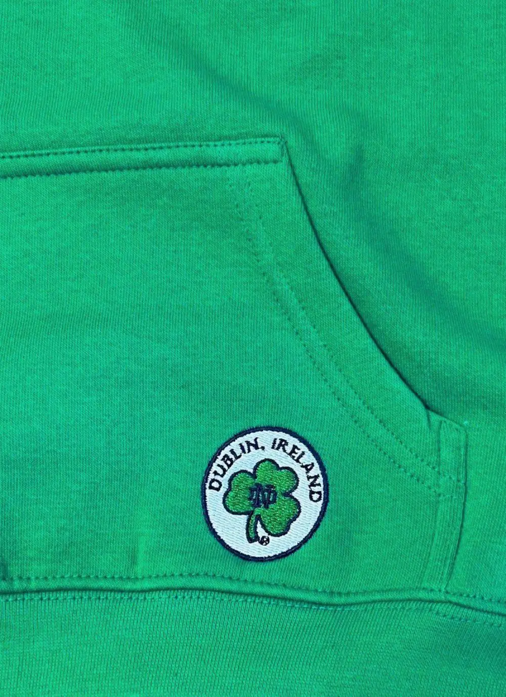 Kids hoodie with green torso, navy sleeves and hood, Ireland printed in the middle with fighting Irish logo