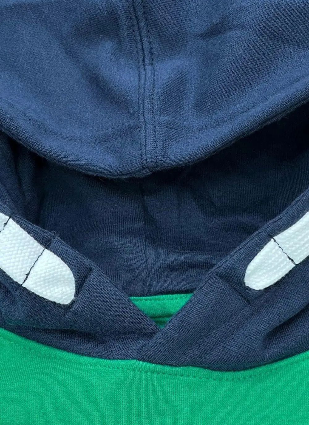Kids hoodie with green torso, navy sleeves and hood, Ireland printed in the middle with fighting Irish logo
