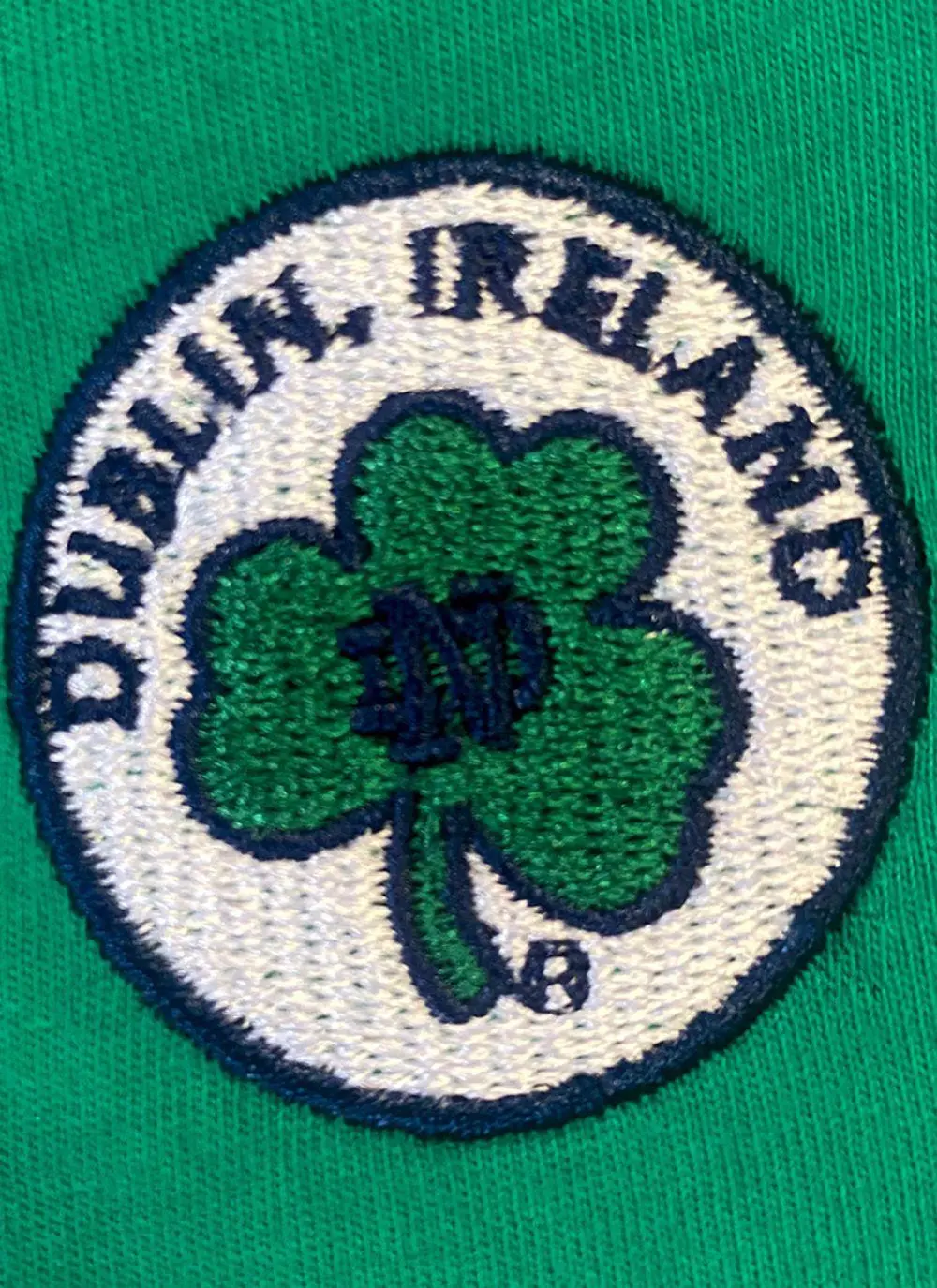 Kids hoodie with green torso, navy sleeves and hood, Ireland printed in the middle with fighting Irish logo