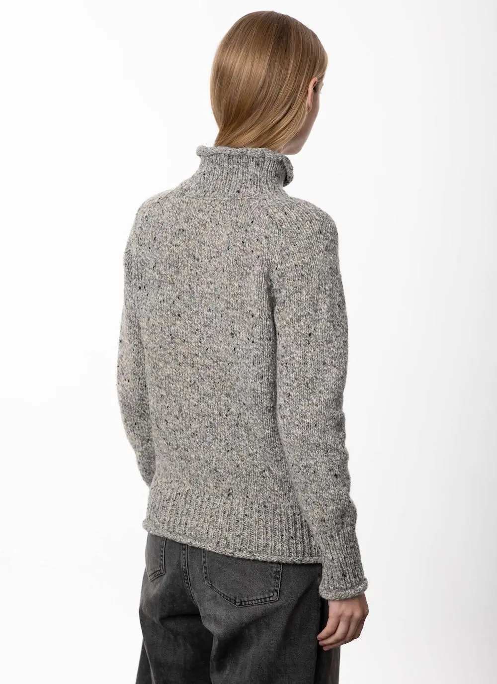 back angle studio shot of blonde woman wearing grey sweater