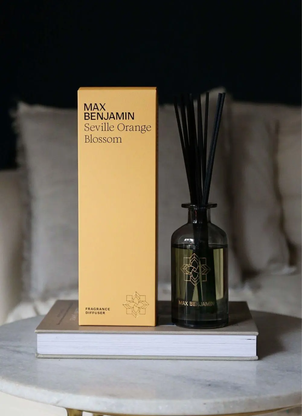 fragrance diffuser with packaging on a table with books