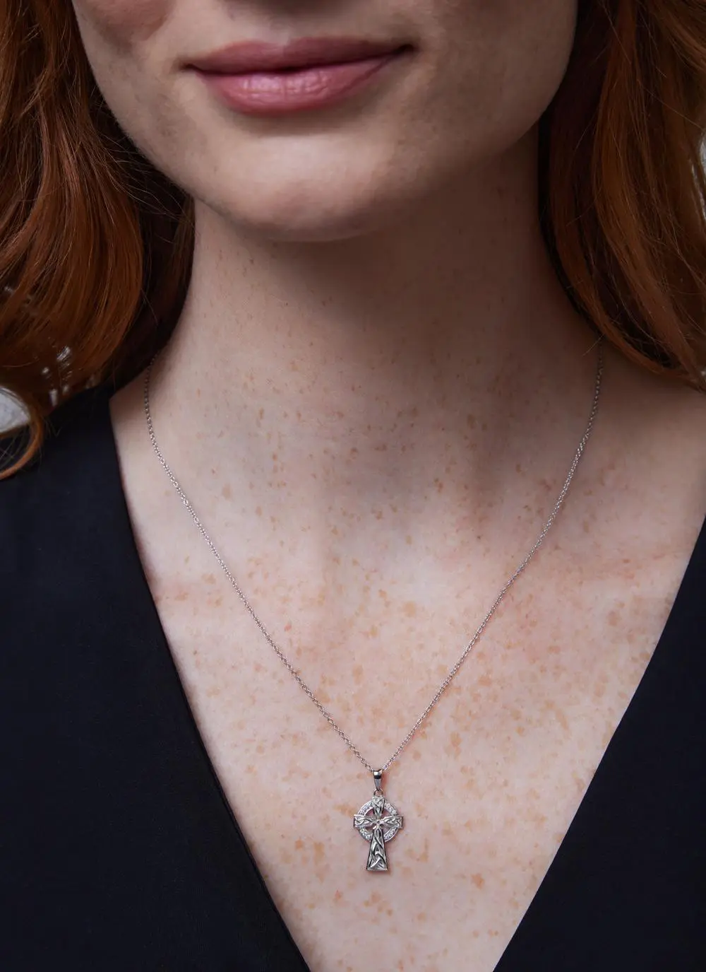 Décolletage shot of red haired woman wearing Sterling Silver Celtic Stone Trinity Knot Sterling Silver Cross
