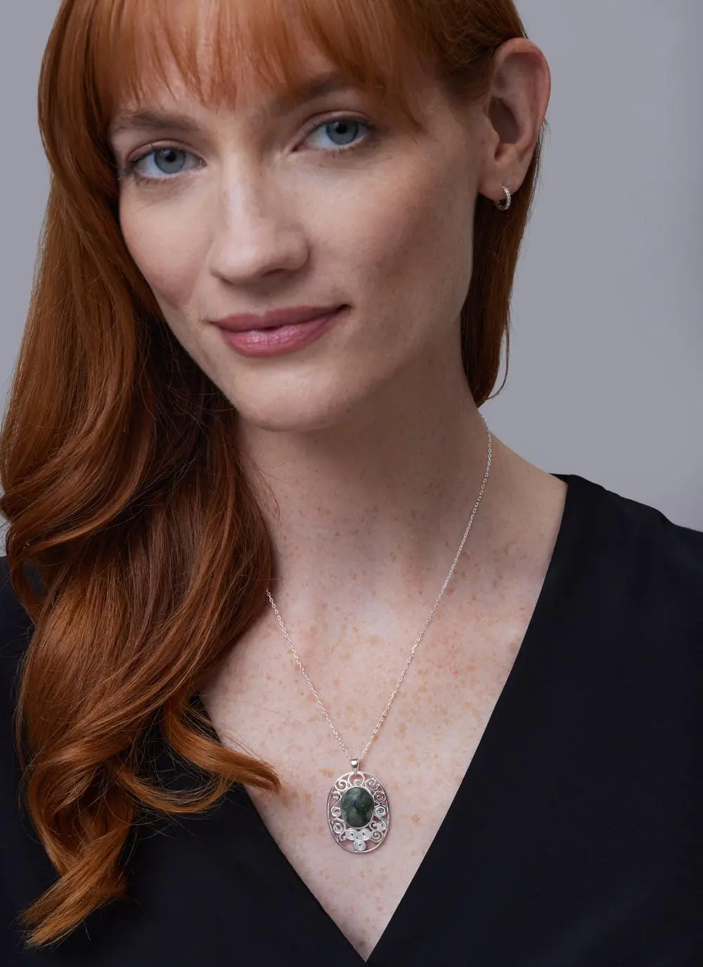Red haired model wearing Sterling Silver Connemara Marble Newgrange Pendant