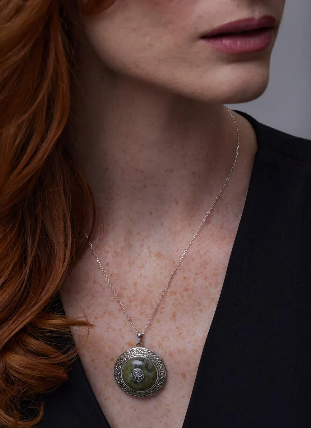 Close up of red haired model wearing Sterling Silver Connemara Marble Trinity Dome Pendant