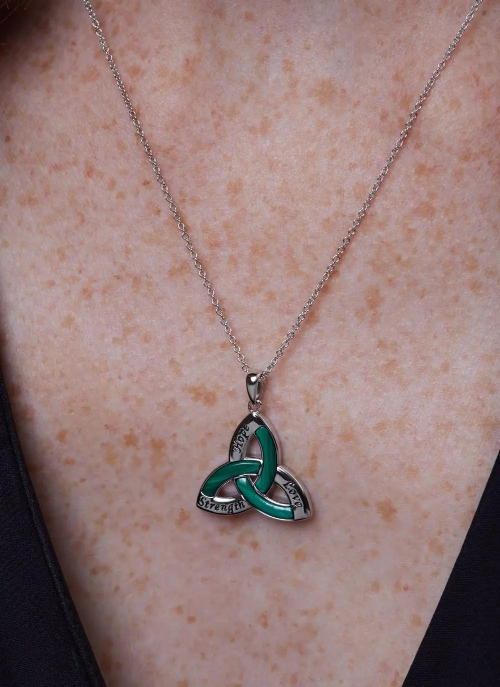 Decolletage shot of Sterling Silver Malachite Trinity Knot Pendant