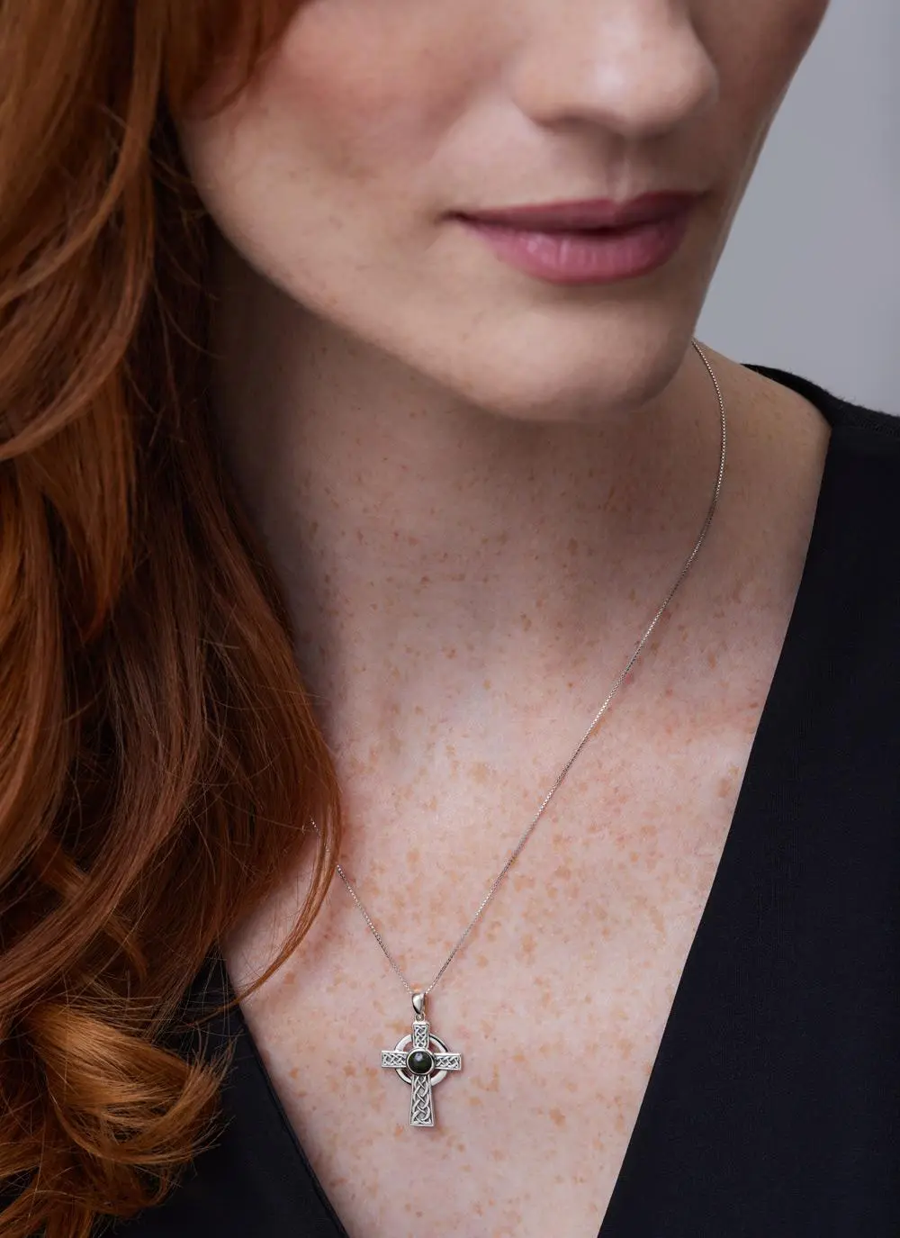 Close up shot of red haired model wearing Sterling Silver Small Connemara Celtic Cross Pendant
