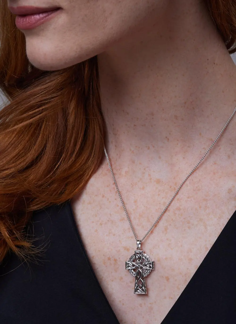 Close up side angle shot of red haired woman wearing Sterling Silver Traditional Large Celtic Cross Pendant