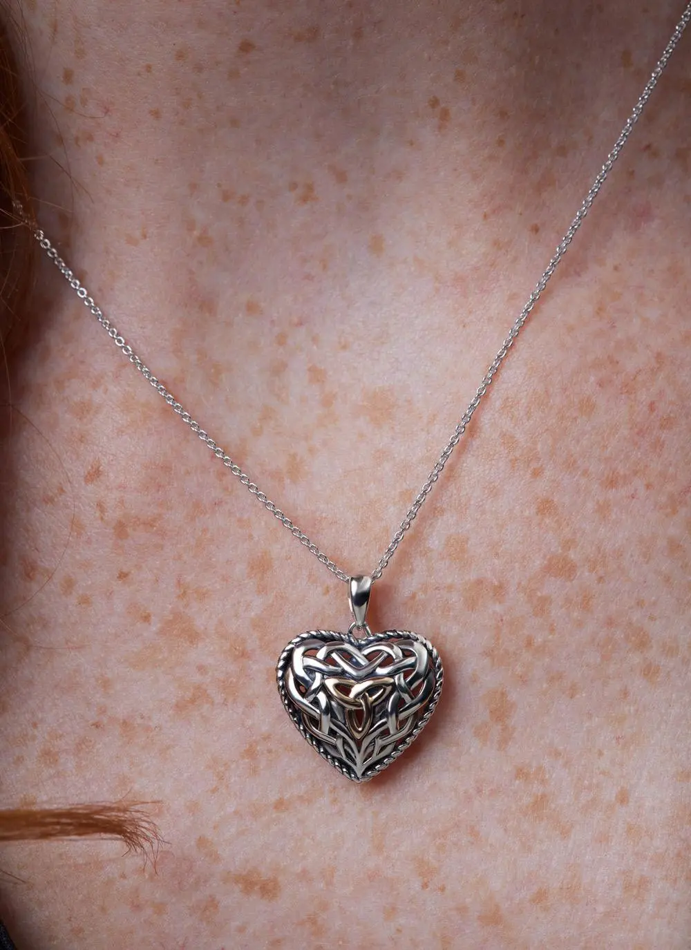 Décolletage shot of Sterling Silver Trinity Knot Heart Pendant