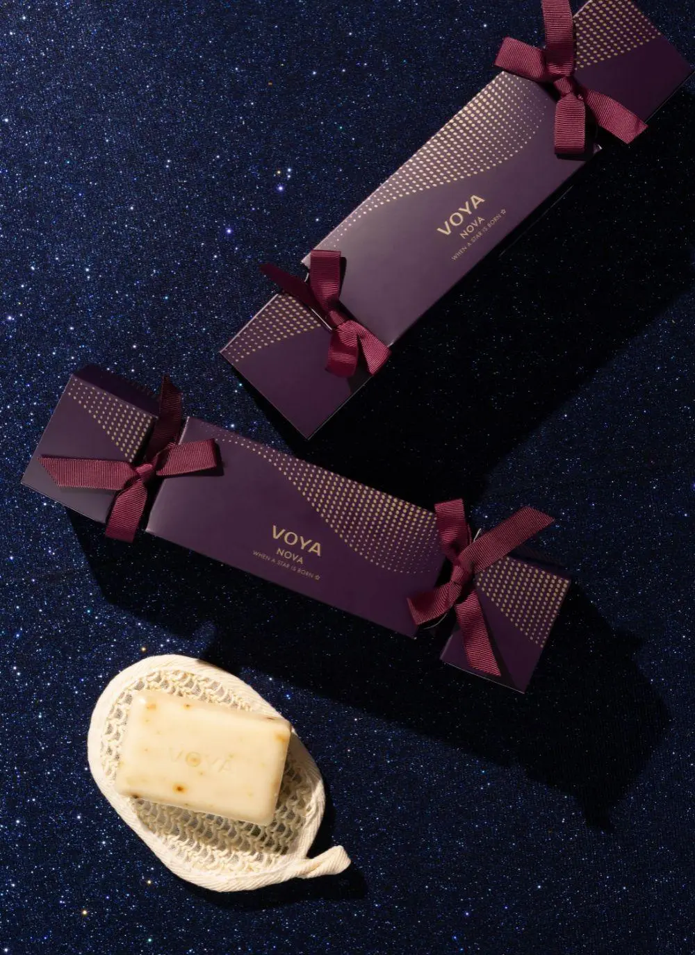 Voya Nova Christmas gift set with products and packaging against purple glittery festive background