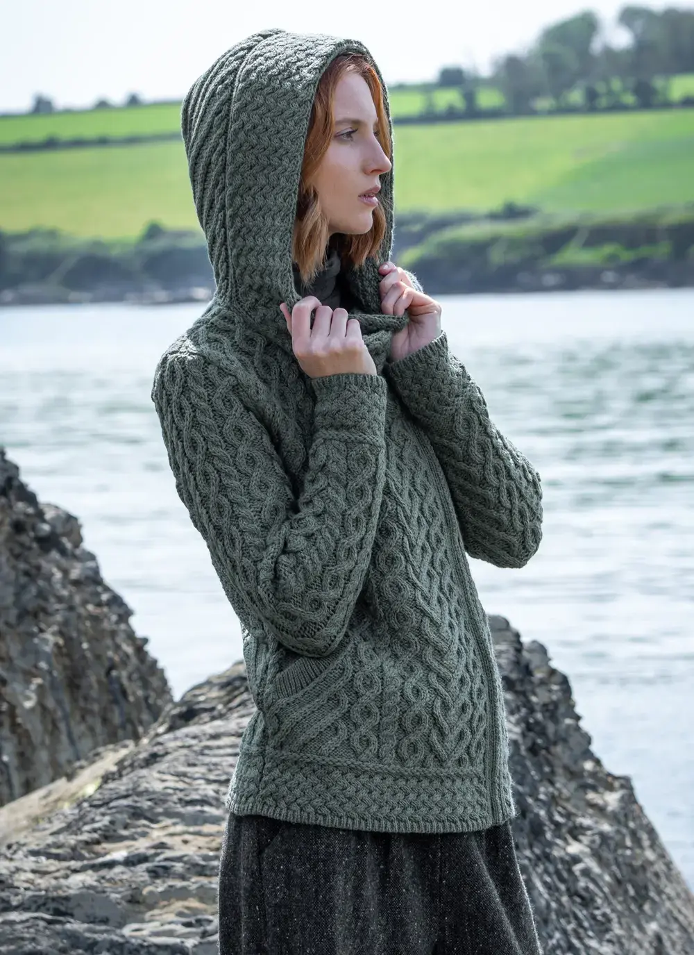 red head model at seaside in tundra aran cable knit biker hoodie hood up side