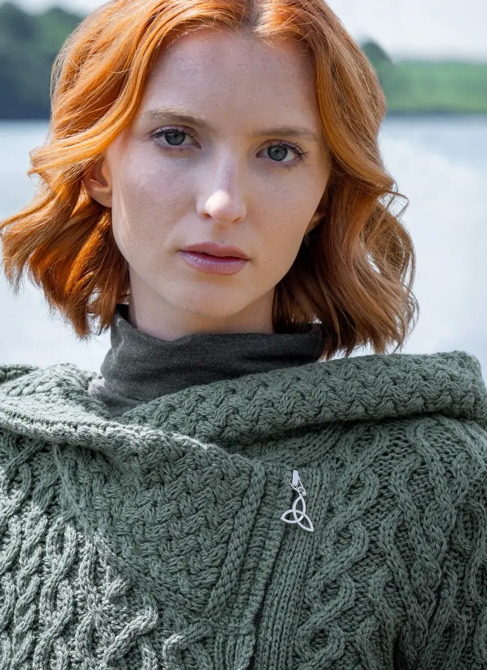 Close up of red head model with sea background detail of collar tundra aran cable knit biker hoodie