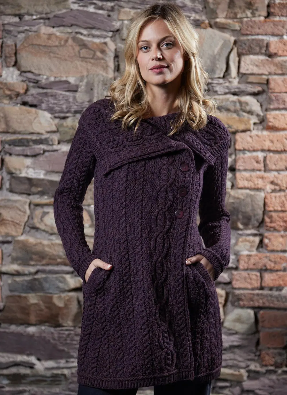 studio shot of blonde woman wearing dark purple aran long aran cardigan