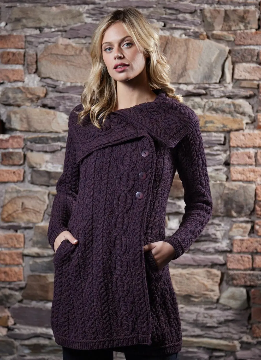 studio shot of blonde woman wearing dark purple aran long aran cardigan