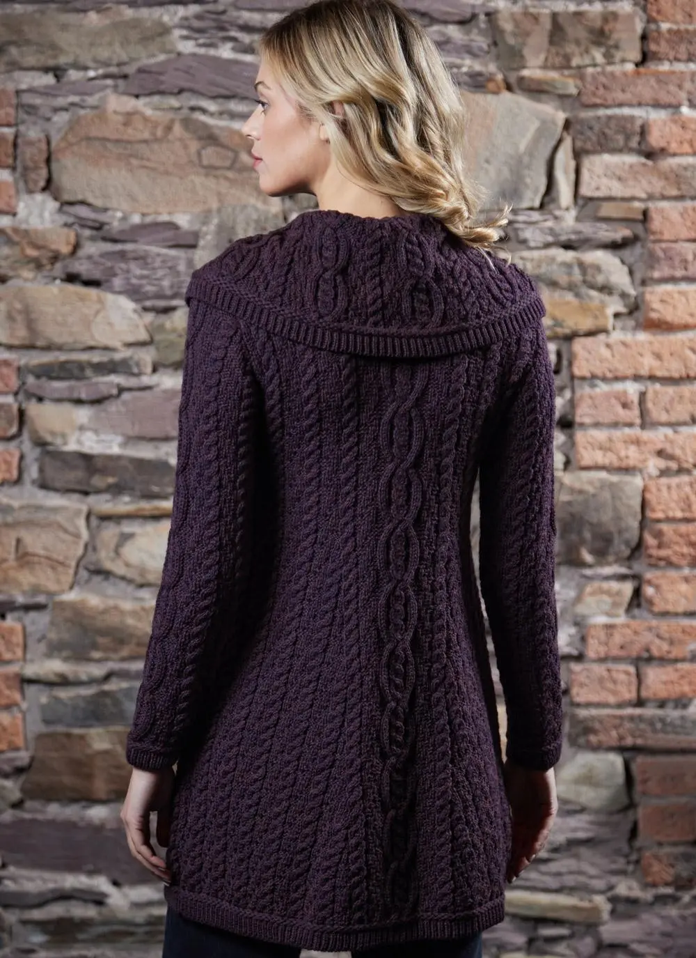 studio shot of blonde woman wearing dark purple aran long aran cardigan
