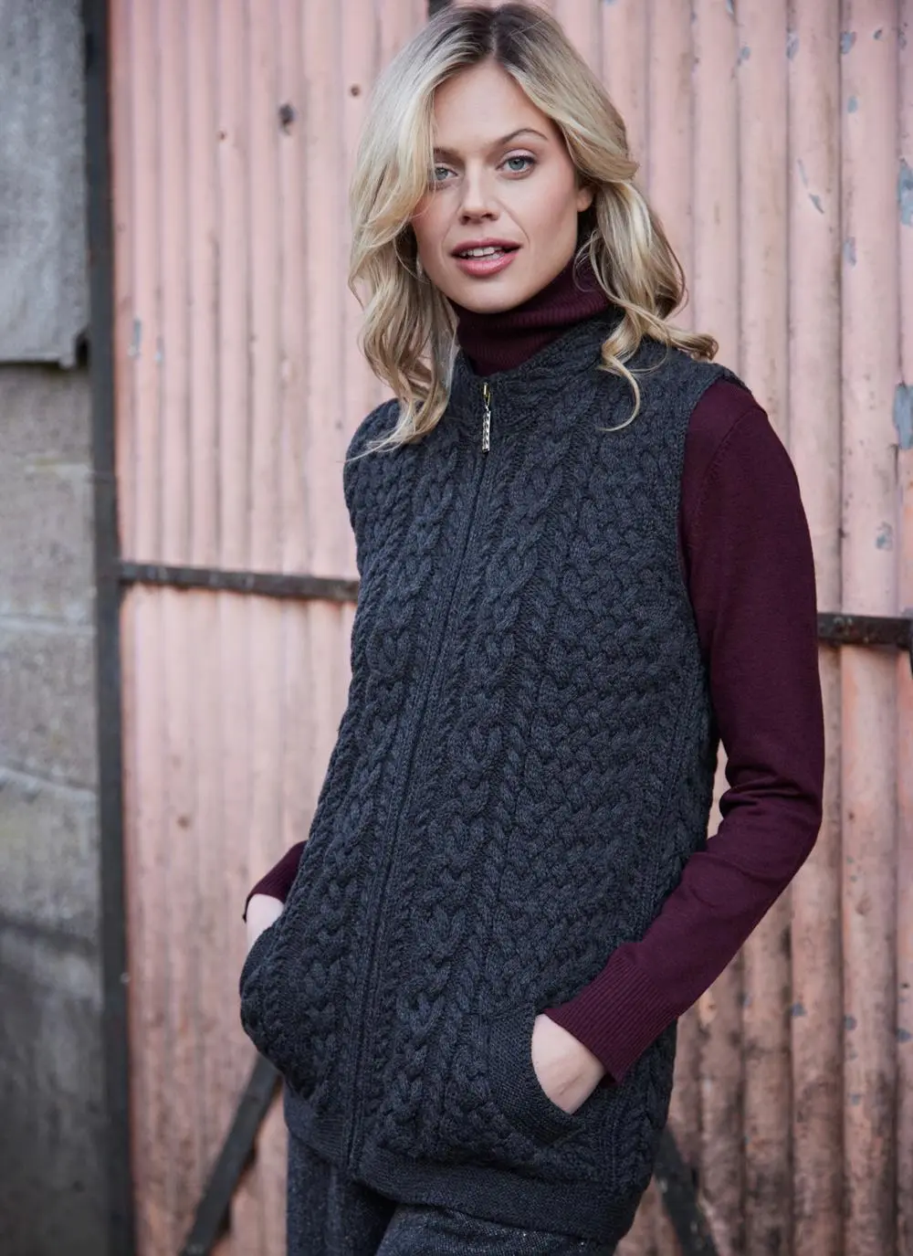 Women standing in front of pink door wearing charcoal aran gilet