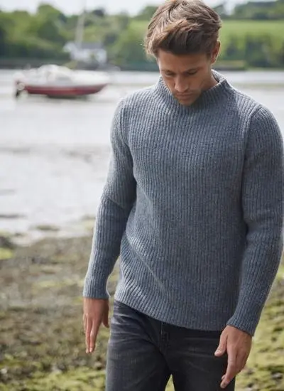 Man on beach wearing a Fisherman Double Down Grey Ribbed Crew Neck Sweater