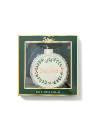 A round, ireland-themed christmas ornament featuring the word 