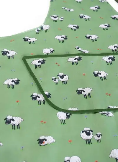 detail of green apron with sheep motif on white background