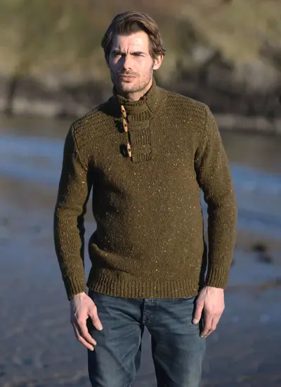Man  on beach wearing olive Fisherman sweater 