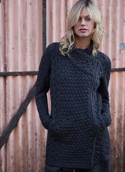 Blonde woman wearing charcoal Aran cardigan with hand in pocket looking ahead
